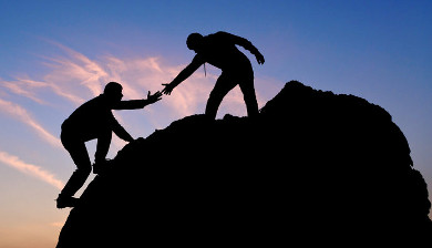 Rock climbers with helping hand